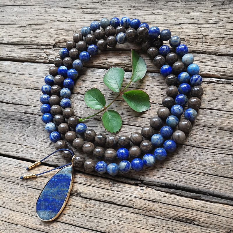 Ce puissant collier mala "confiance en soi" en Lapis Lazuli et Bronzite, lorsqu'il est porté avec intention, aide à se concentrer et à fixer des intentions positives pour soi-même qui cultivent l'amour de soi et la force de caractère. Avec sa combinaison de couleurs audacieuses entre les pierres bleues lapis-lazuli et les accents bronzés de la bronzite, ce collier est un beau rappel de la confiance en son intuition et de la foi en ses décisions.