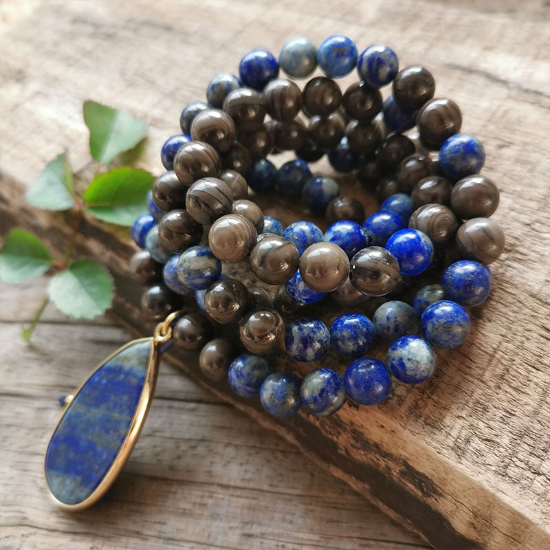 Ce puissant collier mala "confiance en soi" en Lapis Lazuli et Bronzite, lorsqu'il est porté avec intention, aide à se concentrer et à fixer des intentions positives pour soi-même qui cultivent l'amour de soi et la force de caractère. Avec sa combinaison de couleurs audacieuses entre les pierres bleues lapis-lazuli et les accents bronzés de la bronzite, ce collier est un beau rappel de la confiance en son intuition et de la foi en ses décisions.