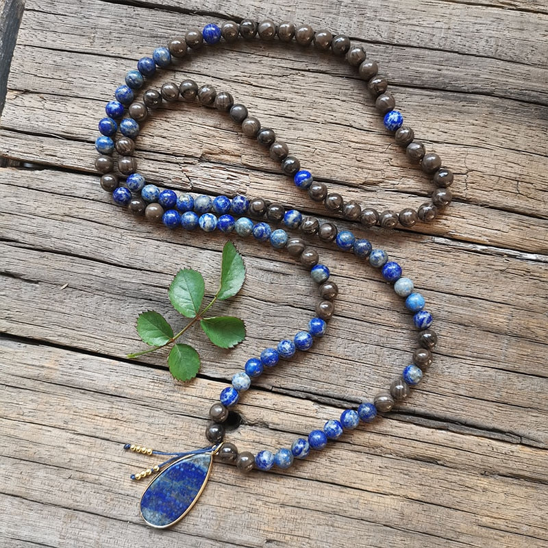 Ce puissant collier mala "confiance en soi" en Lapis Lazuli et Bronzite, lorsqu'il est porté avec intention, aide à se concentrer et à fixer des intentions positives pour soi-même qui cultivent l'amour de soi et la force de caractère. Avec sa combinaison de couleurs audacieuses entre les pierres bleues lapis-lazuli et les accents bronzés de la bronzite, ce collier est un beau rappel de la confiance en son intuition et de la foi en ses décisions.